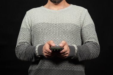 Önünde akıllı telefon tutan beyaz kazaklı bir adama yaklaş.