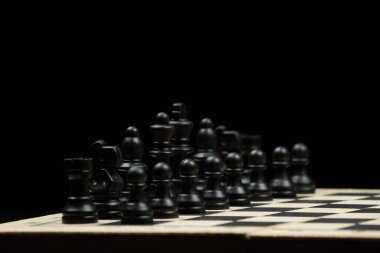 Bir satranç tahtası ve siyah arkaplan üzerinde ekranın sol tarafında bir siyah satranç taşı yakın