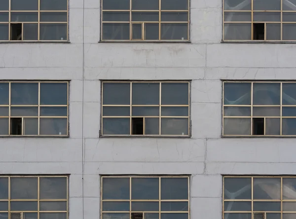 Antigo edifício industrial. Uma parede cinza com grandes janelas . — Fotografia de Stock