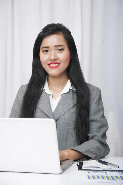 Assistente amigável sentado na frente do laptop — Fotografia de Stock