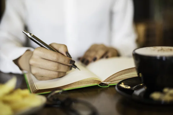 Woman writing her notebook — Stock Photo, Image