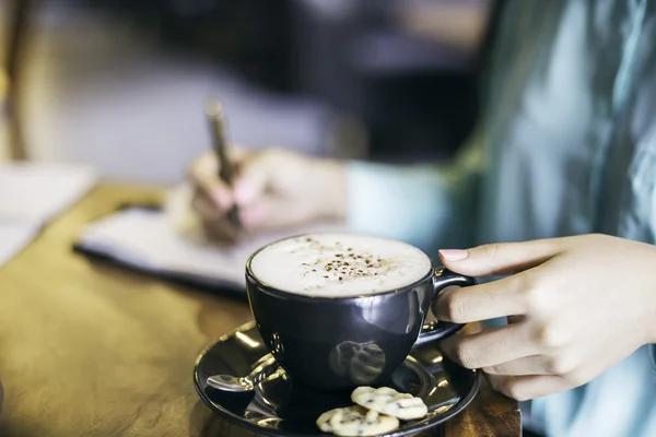 Kvinna med en kopp cappuccino — Stockfoto