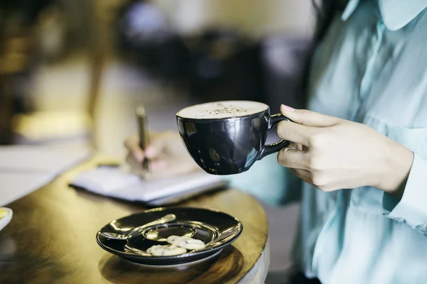 Γυναίκα που κατέχει ένα φλυτζάνι του cappuccino — Φωτογραφία Αρχείου