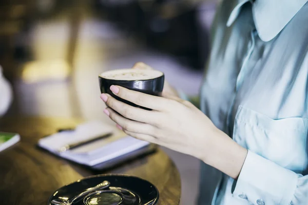 Femme tenant une tasse de cappuccino — Photo