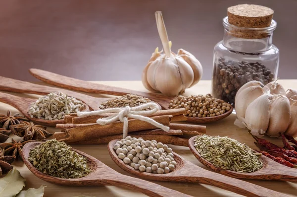 Spoons and spices on cutting board — Stock Photo, Image