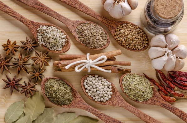 Spoons and spices on cutting board — Stock Photo, Image