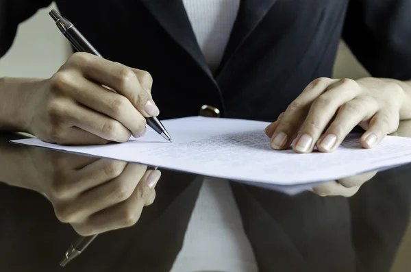 Uma mulher a assinar um contrato — Fotografia de Stock