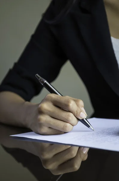 Eine Frau unterschreibt einen Vertrag — Stockfoto