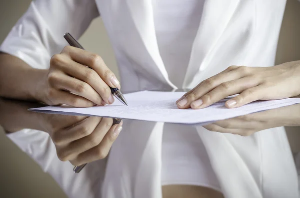 Eine Frau unterschreibt einen Vertrag — Stockfoto