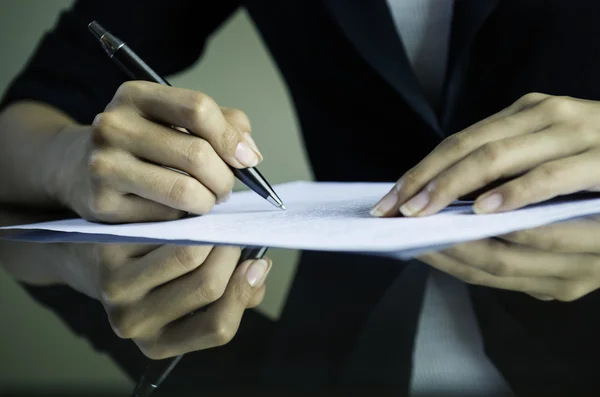 Una mujer firmando un contrato Imágenes de stock libres de derechos