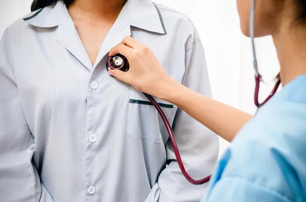 Doctor listening to patient heart — Stock Photo, Image