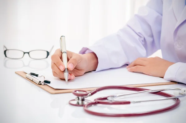 Doctor escribiendo historial médico — Foto de Stock