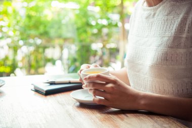 Elinde çay tutan bir kadın.