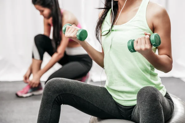 Woman lift weight while sitting — Stock Photo, Image