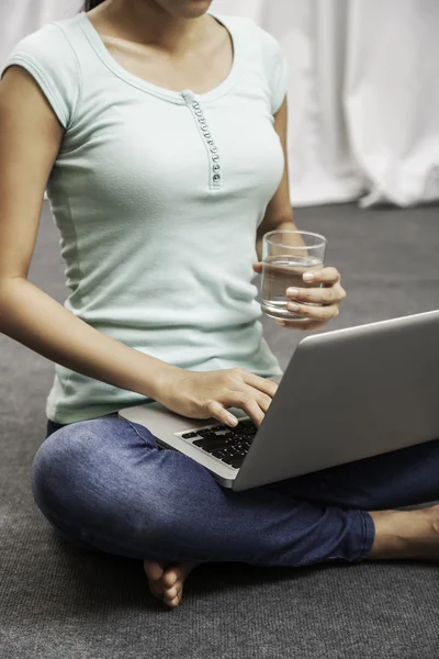 Ung kvinna sitter medan du använder laptop — Stockfoto