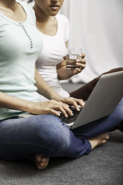 Jonge vrouwen zitten en met behulp van laptop — Stockfoto