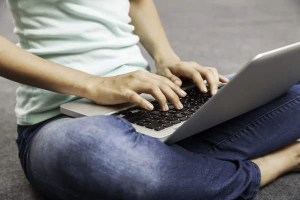 Ung kvinna sitter medan du använder laptop — Stockfoto