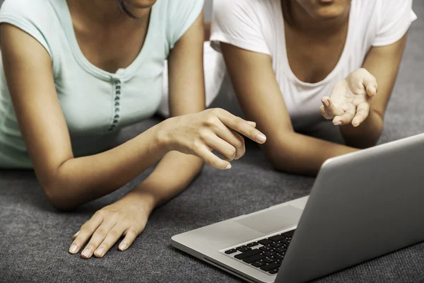 Young women laying while using laptop — Stock Photo, Image