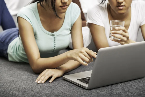 노트북을 사용 하는 동안 누워 젊은 여성 — 스톡 사진