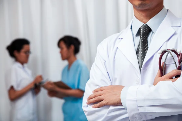 Doctor folding his arms with stethoscope in one hand — Stock Photo, Image