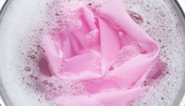 Renkli giysiler toz deterjana batırılmış su çözeltisi. Çamaşır konsepti