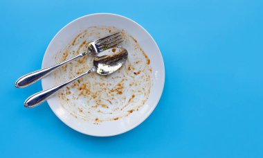 Mavi arka planda kirli tabak. Üst görünüm