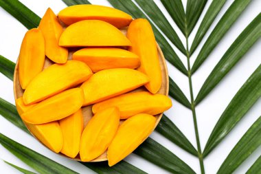 Mango tropikal palmiye yapraklarında ahşap tabakta dilimler. Üst görünüm