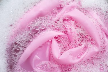 Renkli giysiler toz deterjana batırılmış su çözeltisi. Çamaşır konsepti