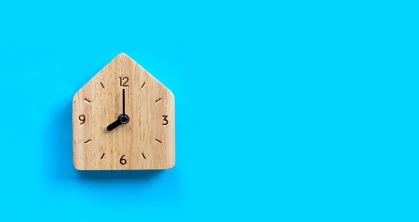 青の背景にミニチュアハウス木製の時計 スペースのコピー — ストック写真