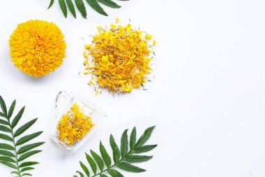 Beyaz arka planda kadife çiçeği yaprakları olan cam bir bardak. Çiçekli bitki çayı konsepti. Boşluğu kopyala