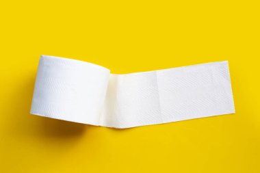 Sarı arka planda tuvalet kağıdı. Boşluğu kopyala