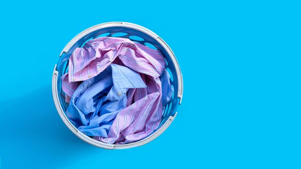 Clothes with a laundry basket on blue background.