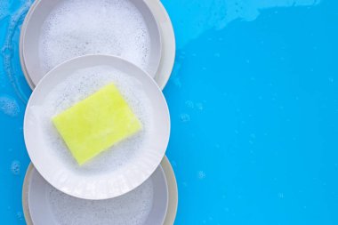 Bulaşık yıkama konsepti ıslak mavi arka planda. Üst görünüm