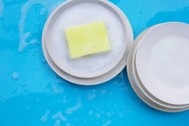 Bulaşık yıkama konsepti ıslak mavi arka planda. Üst görünüm