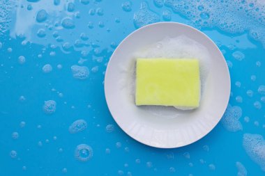 Bulaşık yıkama kavramı. Sabunlu köpük arkaplanlı nemli mavi.