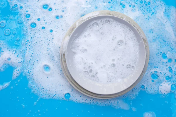 Platos Lavado Sobre Fondo Azul Húmedo Con Espuma Jabonosa — Foto de Stock