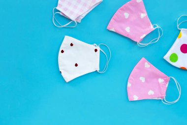 Mavi arkaplanda el yapımı renkli kumaş maskeler.