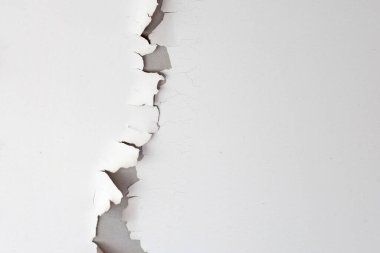 Tavan arasında beyaz renkli boya soyuluyor. Çatının altında.