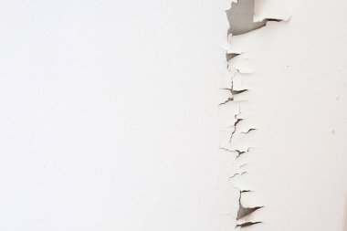 Tavan arasında beyaz renkli boya soyuluyor. Çatının altında.