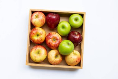 Beyaz arka planda tahta kutuda taze elmalar.