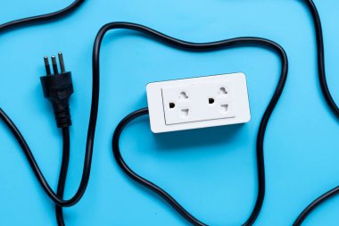 Elektrik kablosu ve fişi mavi arka planda. Üst görünüm