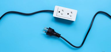 Elektrik kablosu ve fişi mavi arka planda. Üst görünüm