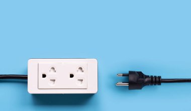 Elektrik kablosu ve fişi mavi arka planda. Üst görünüm