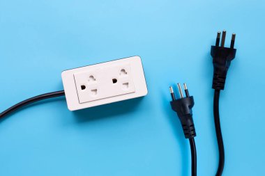 Elektrik kablosu ve fişler mavi arka planda. Üst görünüm