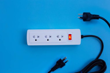 Elektrik kablosu ve fişi mavi arka planda. Üst görünüm