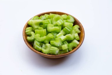 Beyaz arka planda tahta kasede kereviz dilimleri.