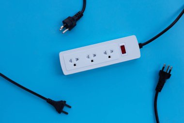 Elektrik kablosu ve fişi mavi arka planda. Üst görünüm