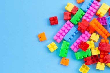 Mavi arkaplanda plastik yapı taşları.
