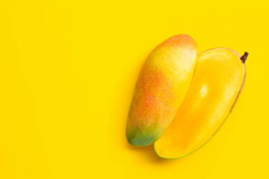 Sarı arka planda olgun mango. Boşluğu kopyala