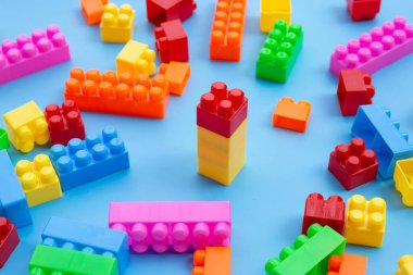 Mavi arkaplanda plastik yapı taşları.